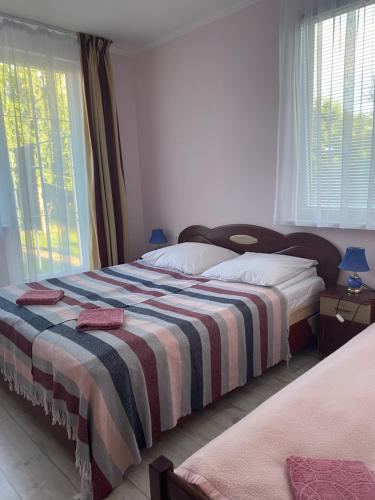 别列戈沃Будинок для відпочинку Dana的一间卧室配有两张床和条纹毯子