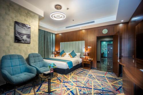 吉达Donatello Jeddah Hotel的酒店客房,配有一张床和两把椅子
