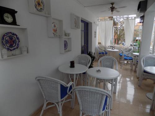埃尔阿雷纳尔玛如织别墅酒店的一间设有白色桌椅的用餐室
