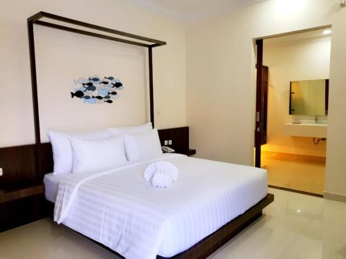 PasarbaruNew Belitung Holiday Resort的卧室配有一张白色大床,卧室内有区域