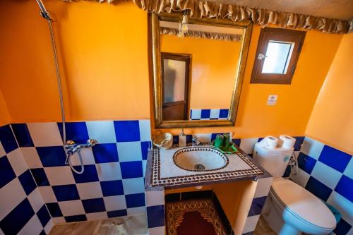 El GoueraAladdin Desert Camp的一间带水槽、镜子和卫生间的浴室