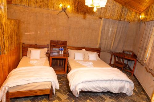 Maruwā GhātBagaicha Adventure Resort Pvt. Ltd.的带2张桌子的房间的两张床