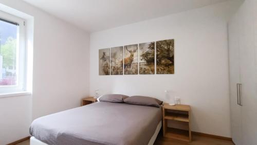马累Relais Gentilini的白色的卧室设有床和窗户