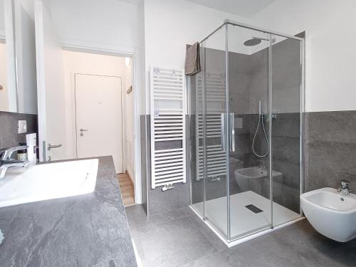 马累Relais Gentilini的一间带玻璃淋浴和水槽的浴室