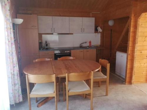 奥伯维尔Chalet Blockhaus auf Camping - b48513的厨房配有木桌和一些椅子