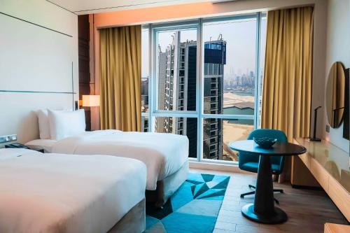 麦纳麦Hilton Bahrain的酒店客房设有两张床和大窗户。