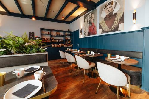 雷讷瑟雷讷瑟酒店的餐厅设有木桌和椅子,拥有蓝色的墙壁