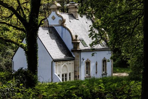 科尔维纳克Domaine de Locguénolé & Spa - Relais & Chateaux的山坡上带屋顶的白色房子