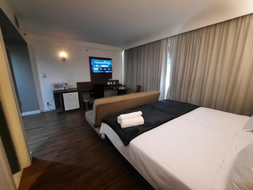 圣保罗Flat Hotel Internacional Ibirapuera 2534的酒店客房设有一张大床和一张书桌。