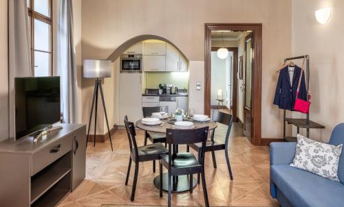 布拉格3 Epoques Apartments by Adrez的客厅配有桌子和蓝色沙发