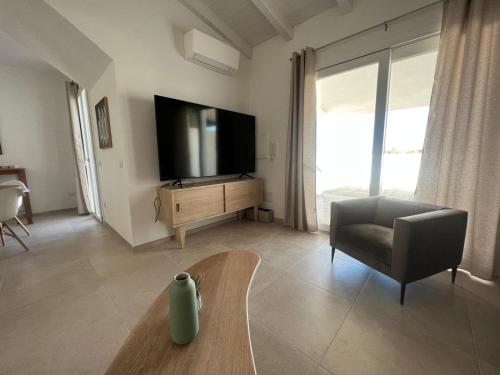 瓦雷多利亚La Casa di Spinosella的客厅配有电视、椅子和桌子