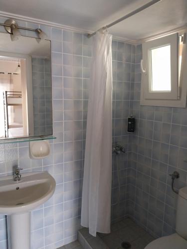 尼基亚娜Aggeliki Apartments的一间带水槽和淋浴帘的浴室