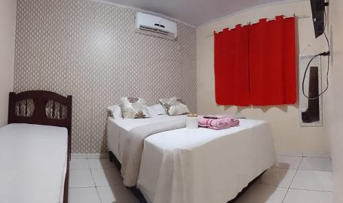 MateirosMACEDO HOSPEDAGEM的一间设有两张床和红色窗帘的房间
