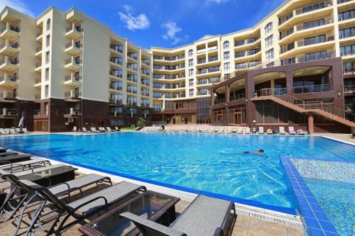 金沙Golden Sands Rentals Apartments的在酒店的游泳池游泳的人