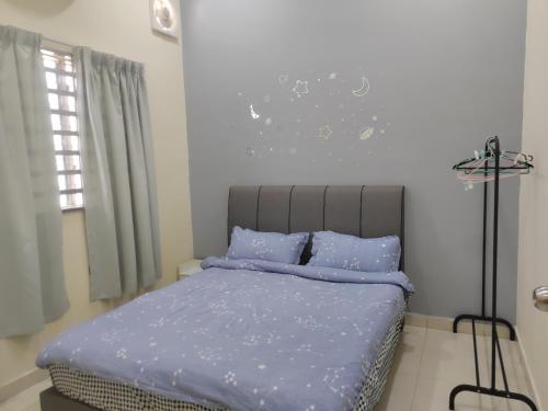 实兆远My Homestay Sitiawan - Astronaut Space House 8 Pax的一间卧室配有一张带蓝色棉被的床