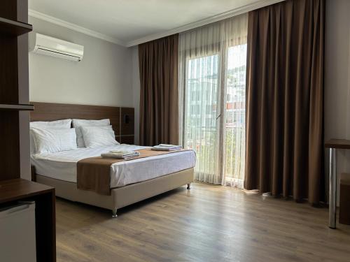 居吕克Gulluk Life Hotel的一间卧室设有一张床和一个大窗户
