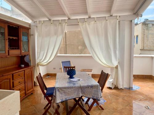 马里迪莫le calette Marettimo的一间带桌椅和窗户的用餐室