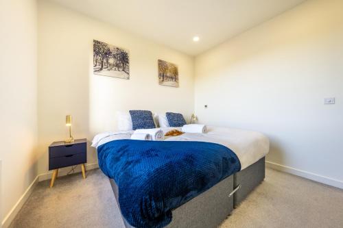 斯蒂夫尼奇Luxury 1 Bedroom serviced apartment with Roof terrace & Gym的一间卧室配有一张带蓝色毯子的大床