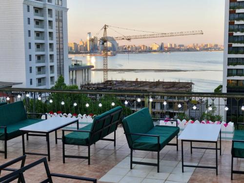 巴库Nur Hotel Sea View的一个带桌椅的庭院,享有城市美景。