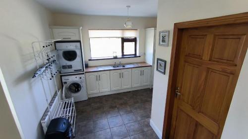 斯温福德Swinford Country House的厨房配有洗衣机、水槽和门
