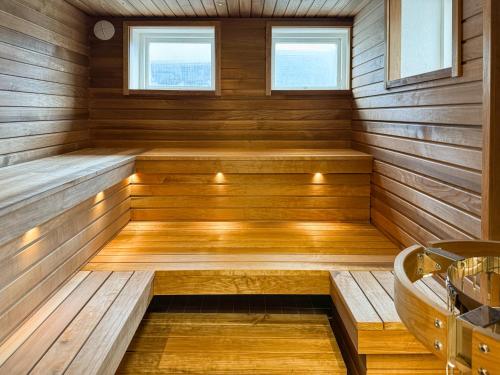 玛丽港Strandnäs Gård的一间带木镶板和浴缸的桑拿浴室