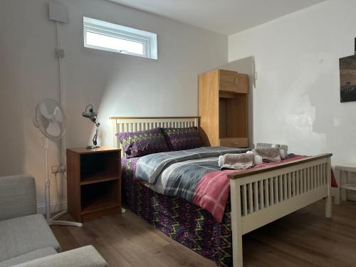 伦敦Reat Bungalow of 207A的一间卧室配有一张大床和木制床头板