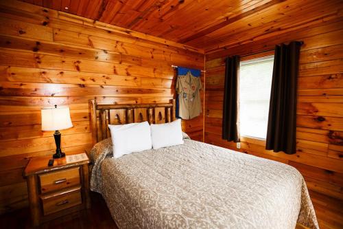 BeaverThe Cabins at Pine Haven - Beckley的小木屋内一间卧室,配有一张床
