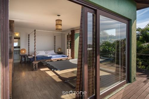 加罗帕巴Casa com vista p mar em Garopaba PSV000的一间带秋千床的卧室和一个阳台