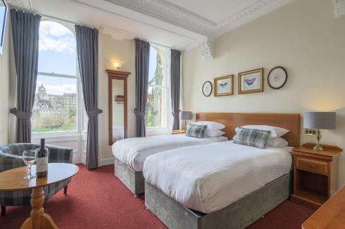 爱丁堡老威弗利酒店的酒店客房设有两张床和一张桌子。