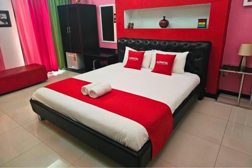 清迈Phu Jaya Floresta Resort by ALPHATEL的一间卧室配有一张带红色和白色枕头的大床