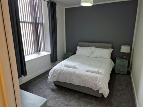 赫尔Suffolk House Apartments HU1的一间卧室配有带白色床单和枕头的床。