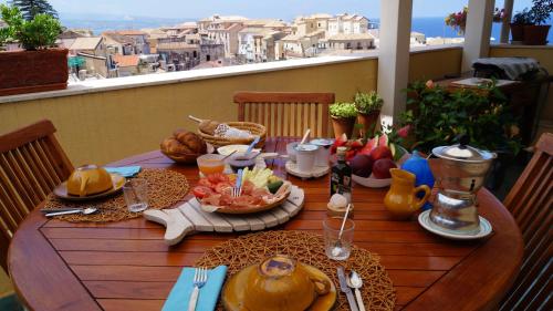 皮佐B&B Il Vicolo Di Pizzo的阳台上的木桌和食物