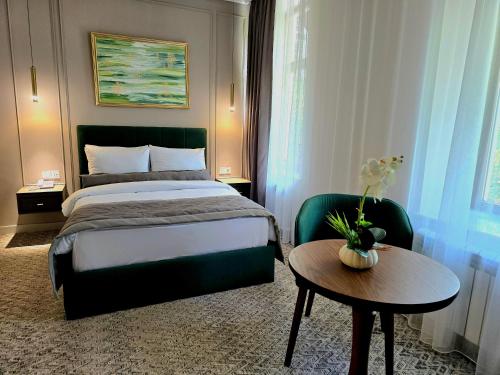 巴库Maestro Address Hotel的酒店客房配有一张床和一张桌子,桌子上装有四面 ⁇ 