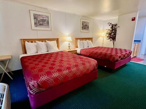 布伦瑞克Rodeway Inn & Suites Brunswick near Hwy 1的酒店客房 - 带两张红色床罩