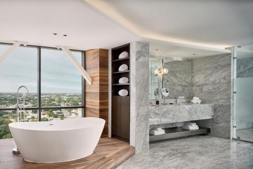 梅里达凯悦梅里达酒店的带浴缸的浴室和大窗户