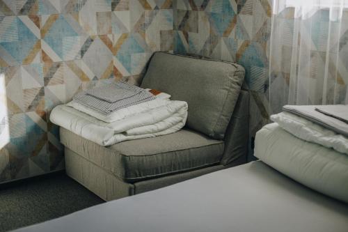 利马诺瓦Apartamenty Leśna的一把椅子,在房间里放着一堆毛巾