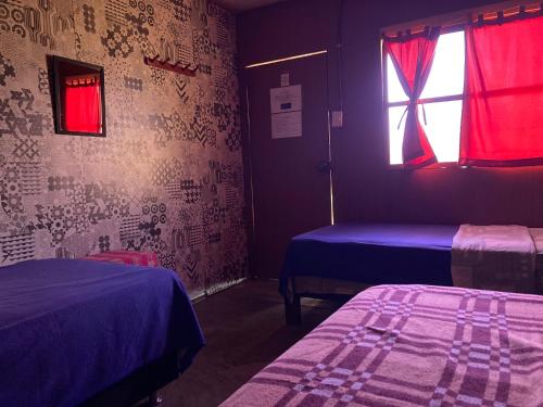 帕拉卡斯Paracas Camp Lodge & Experiences的客房设有两张床和窗户。