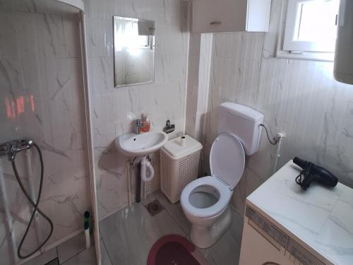 拉克塔希Fly & Stay Apartments的白色的浴室设有卫生间和水槽。