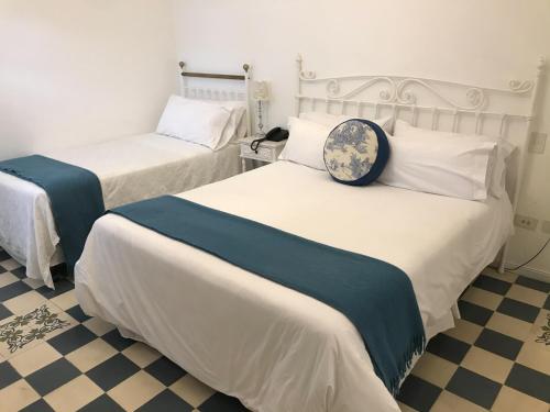 萨尔塔比库尼亚精品酒店的酒店客房带两张床和时钟