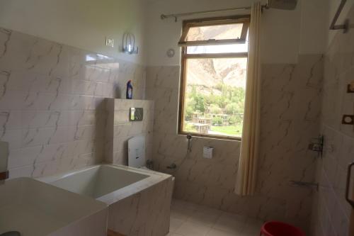TurtokHotel Duktuk的白色的浴室设有浴缸和窗户。