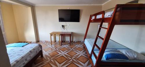 廷戈玛丽亚HOSPEDAJE EL CANTARO II的一间卧室配有两张双层床和一台平面电视