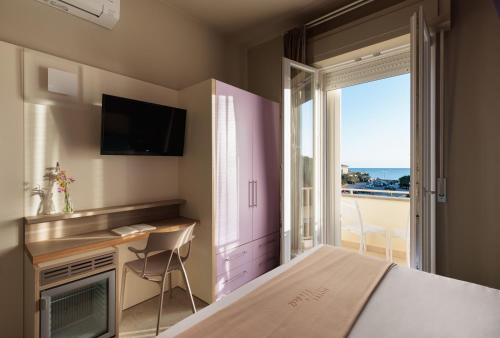 毕博纳的码头尼娜酒店的一间卧室配有一张床、一张书桌和一个窗户。