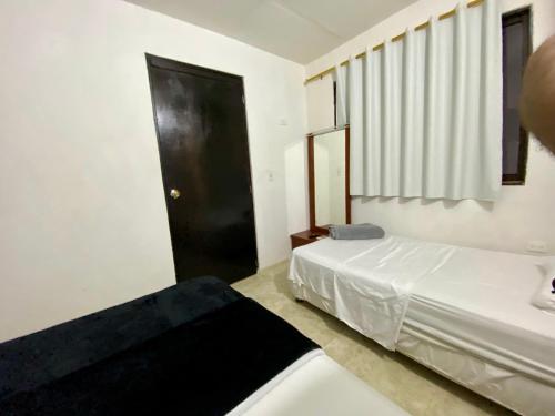 卡塔赫纳Apartamento cerca del aeropuerto的一间卧室设有两张床和一扇黑色的门