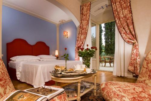 菲利内瓦尔达诺Villa la Borghetta Spa Resort的卧室配有1张床、1张桌子和1把椅子
