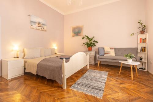布达佩斯Gellerico Rooms at Horánszky Street的一间卧室配有一张床和一张沙发
