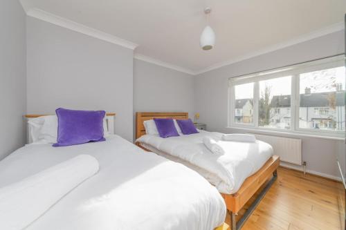 剑桥Holbrook house的紫色枕头间内的两张床