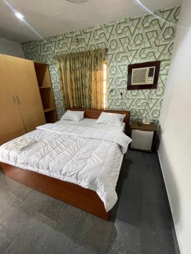 乌约Calawazobia Hotel的一间卧室,卧室内配有一张大床