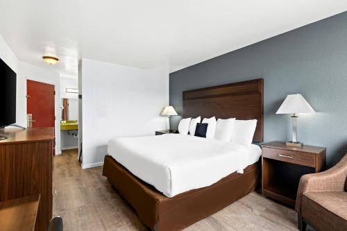 亚基马Red Lion Inn & Suites Yakima的酒店客房设有一张大床和一张沙发。