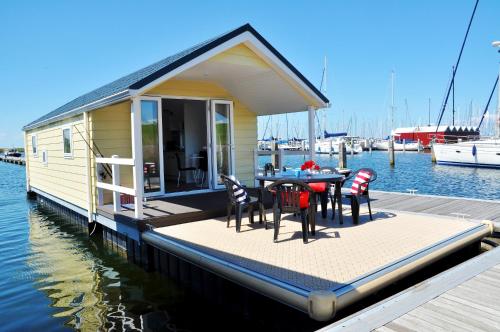 莱利斯塔德弗莱沃码头最佳海滨水上木屋的码头上的房子,配有桌椅