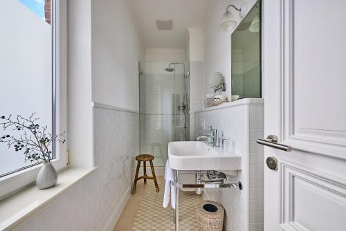霍伦斯特霍伦斯特庭院酒店的白色的浴室设有水槽和淋浴。